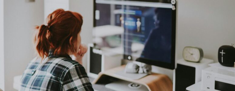 Data entry clerk sitting at a desktop computer working on their side hustle.