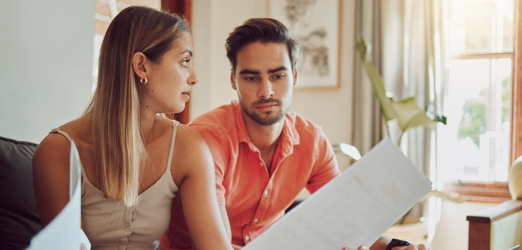 Man and woman sitting on a couch talking about debt