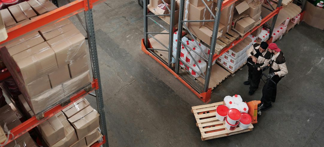 Overhead shot of two workers in a warehouse.